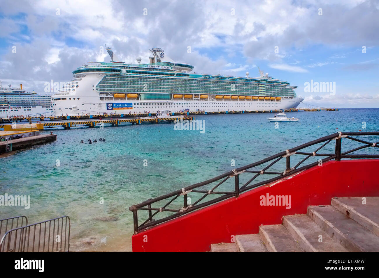 Liberty-class luxury cruise ship, Liberty of the Seas, at port docked at the port in Cozumel, Mexico. Passengers walk on dock. Stock Photo