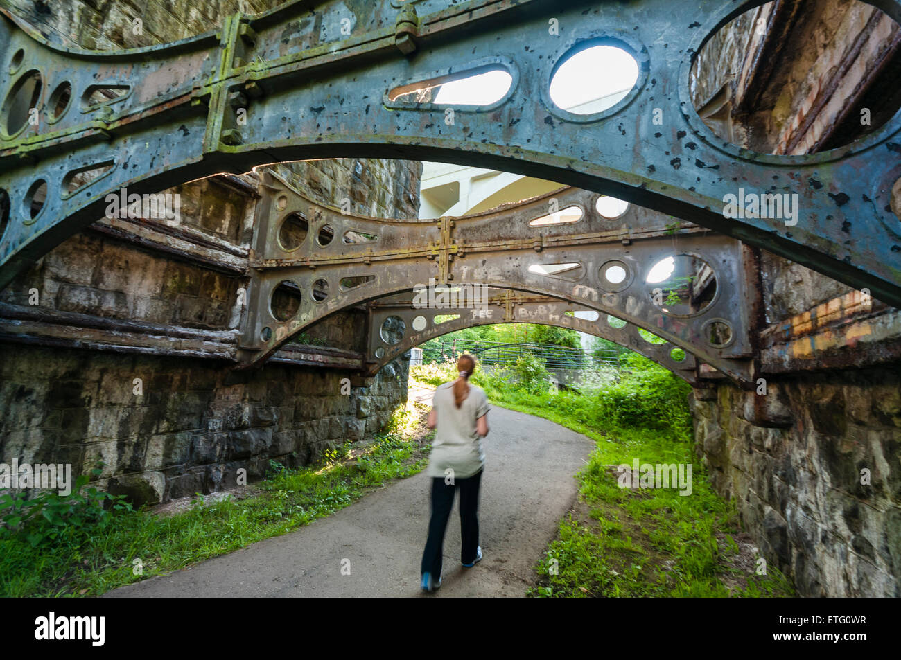 A woman walks underneath the arch of a Victorian viaduct Stock Photo