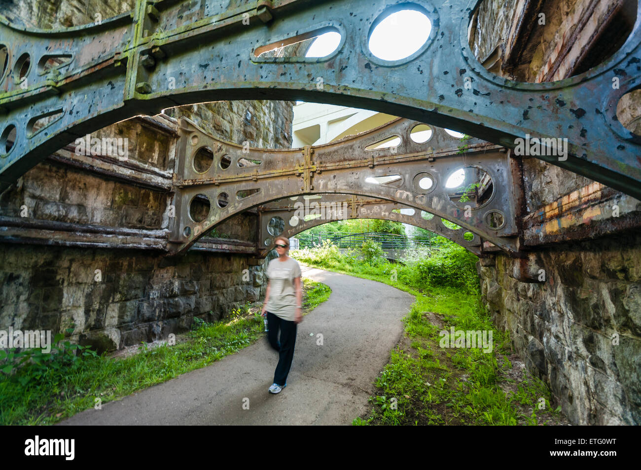 A woman walks underneath the arch of a Victorian viaduct Stock Photo