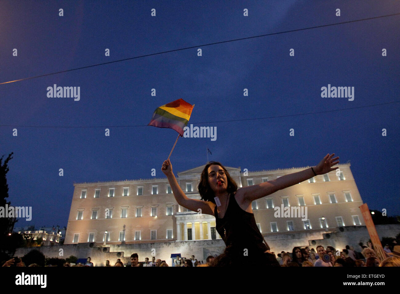 Athens, Greece. 13th June, 2015. A protester waves a rainbow flag ...