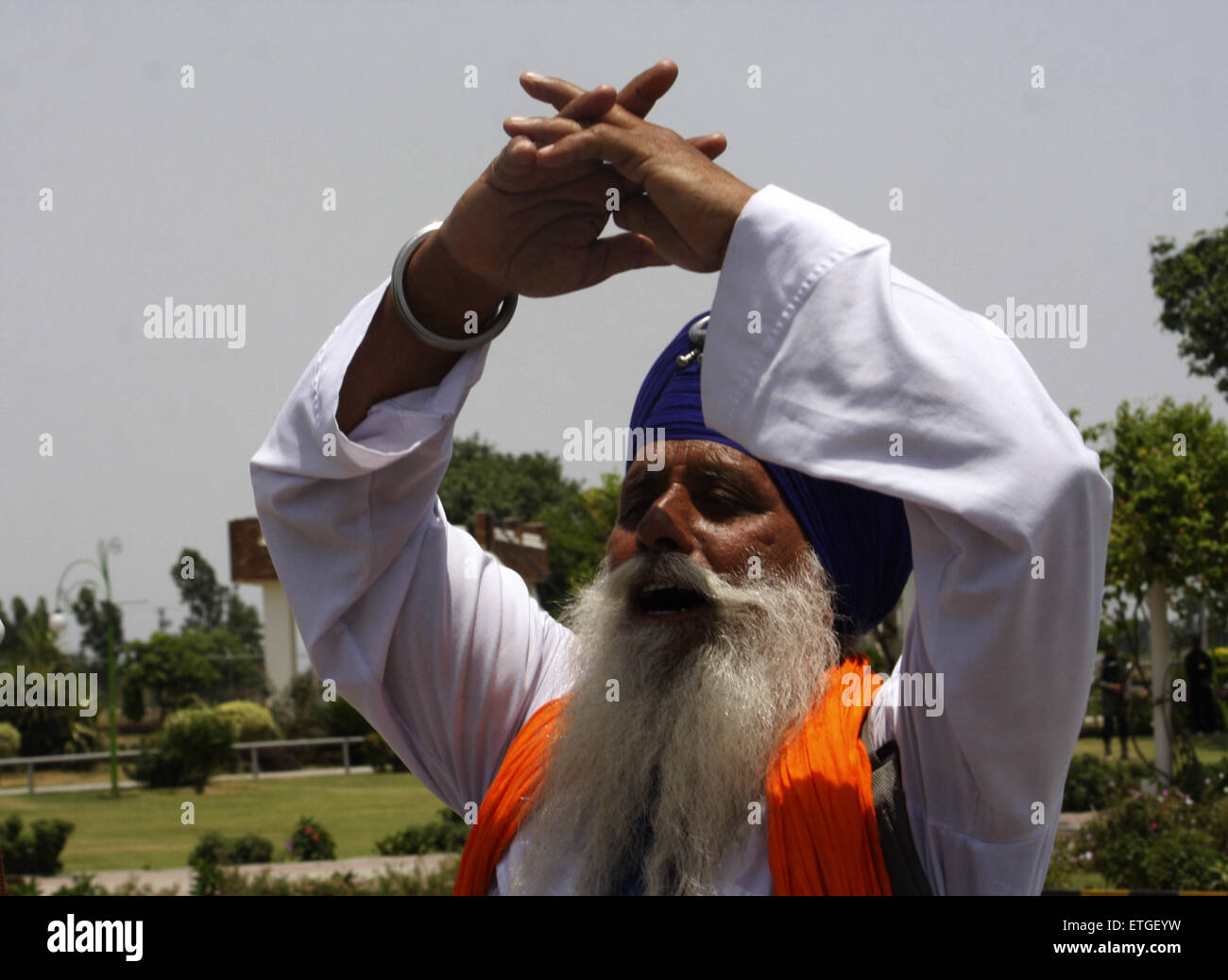 Lahore. 13th June, 2015. An Indian Sikh pilgrim prays after crossing the Wagha border post in eastern Pakistan's Lahore on June 13, 2015. Hundreds of Sikh pilgrims arrived in Pakistan on Saturday to attend ceremonies marking the death of the fifth Sikh Guru, Arjan Dev Ji. © Jamil Ahmed/Xinhua/Alamy Live News Stock Photo