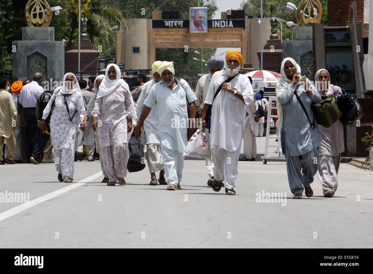 Lahore. 13th June, 2015. Indian Sikh pilgrims cross the Wagha border post in eastern Pakistan's Lahore on June 13, 2015. Hundreds of Sikh pilgrims arrived in Pakistan on Saturday to attend ceremonies marking the death of the fifth Sikh Guru, Arjan Dev Ji. © Jamil Ahmed/Xinhua/Alamy Live News Stock Photo
