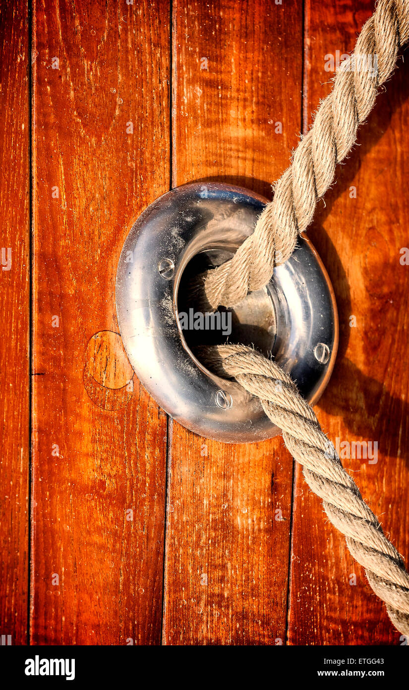 Vintage toned wooden yacht background with rope and porthole. Stock Photo