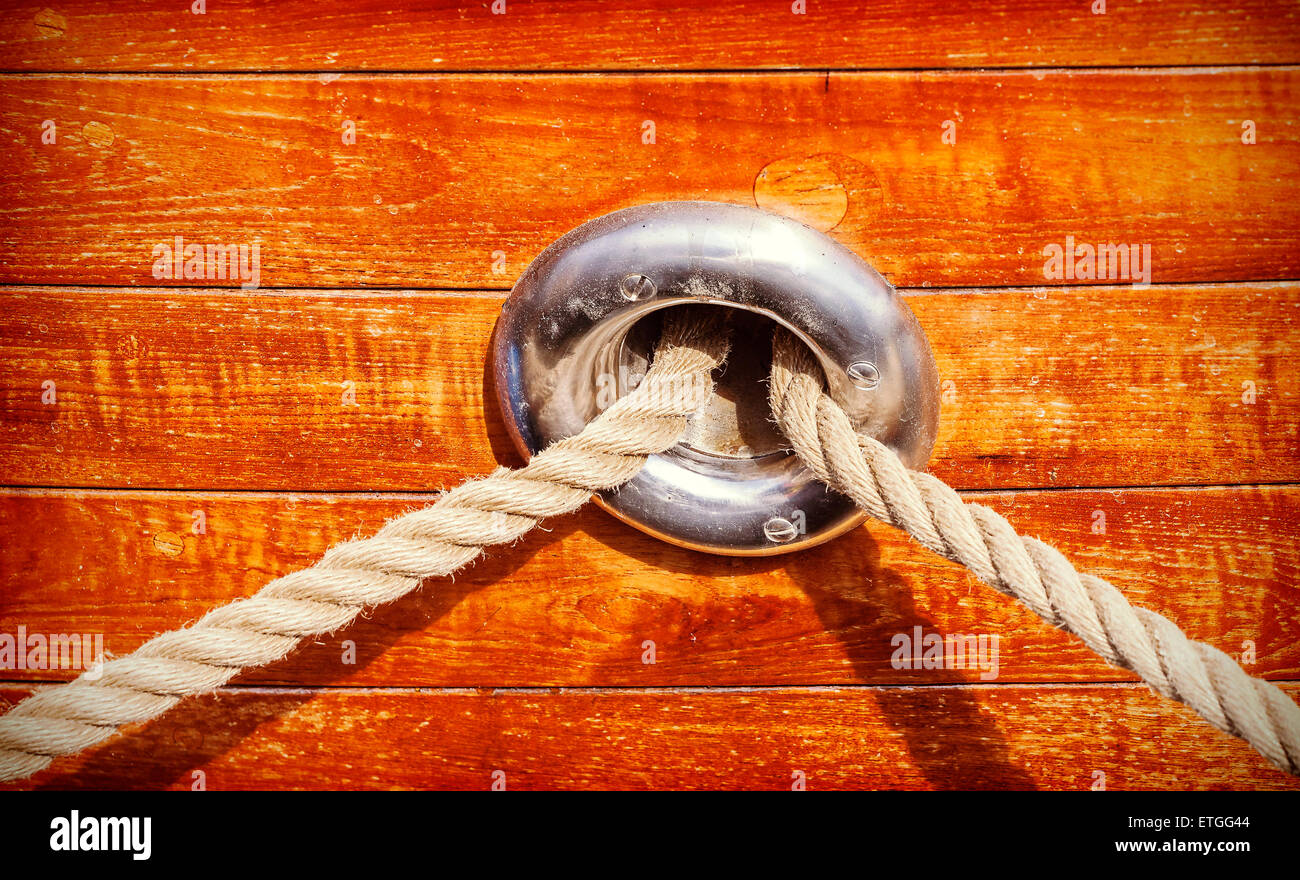 Vintage toned wooden yacht background with rope and porthole. Stock Photo