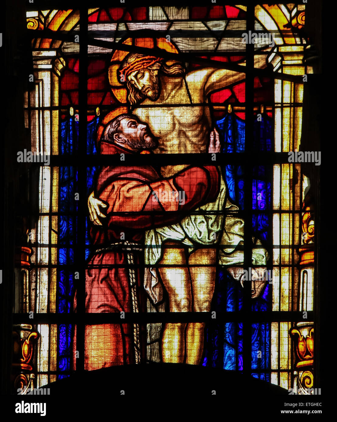 Stained glass window depicting Saint Francis embracing Jesus on the