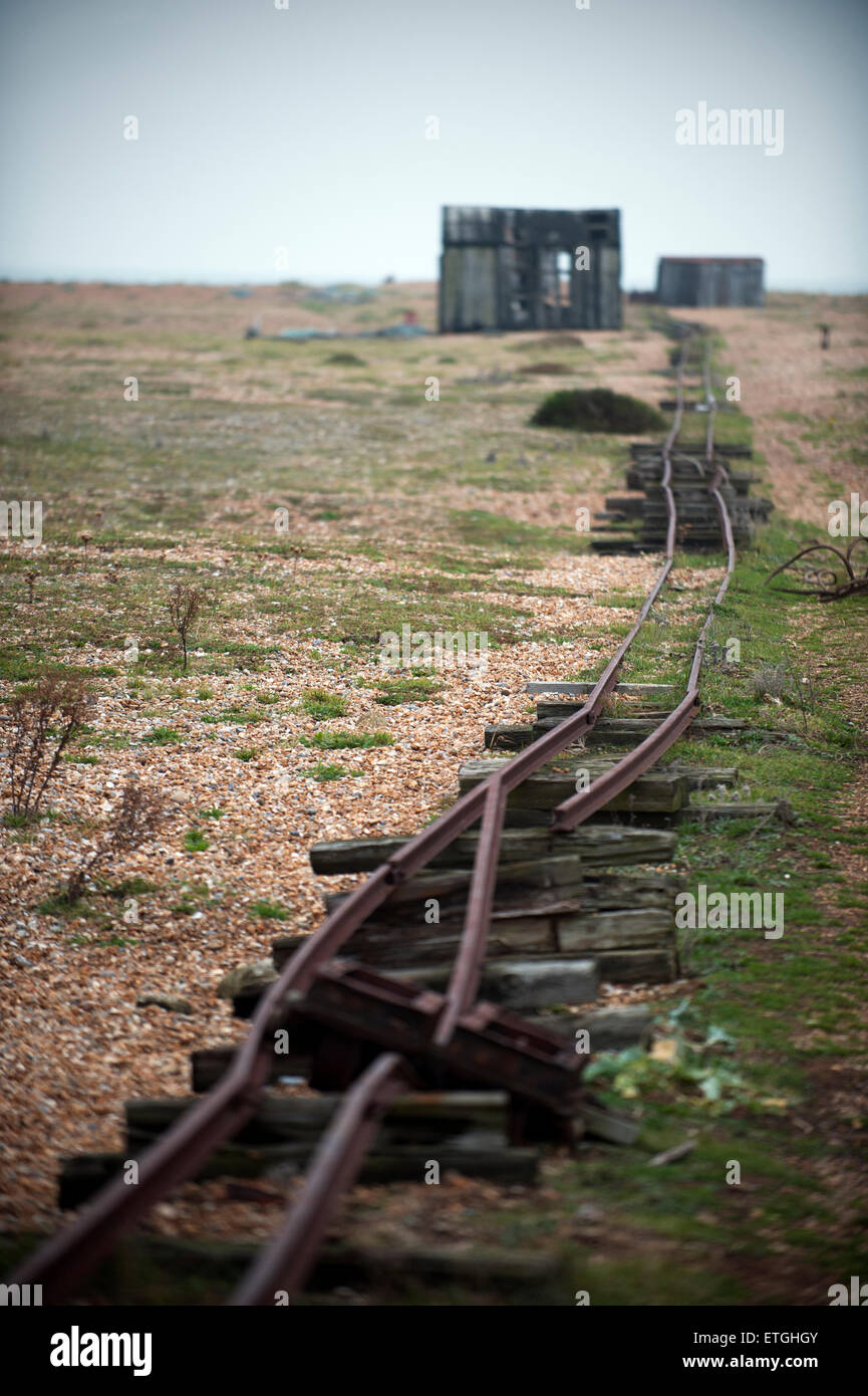 Old rail line and wooden fishermen huts at shingle beach in Dungeness Kent England UK Europe Stock Photo