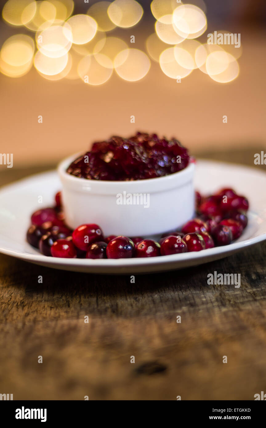 Bowl of fresh cranberry sauce with whole cranberries on white plate Stock Photo