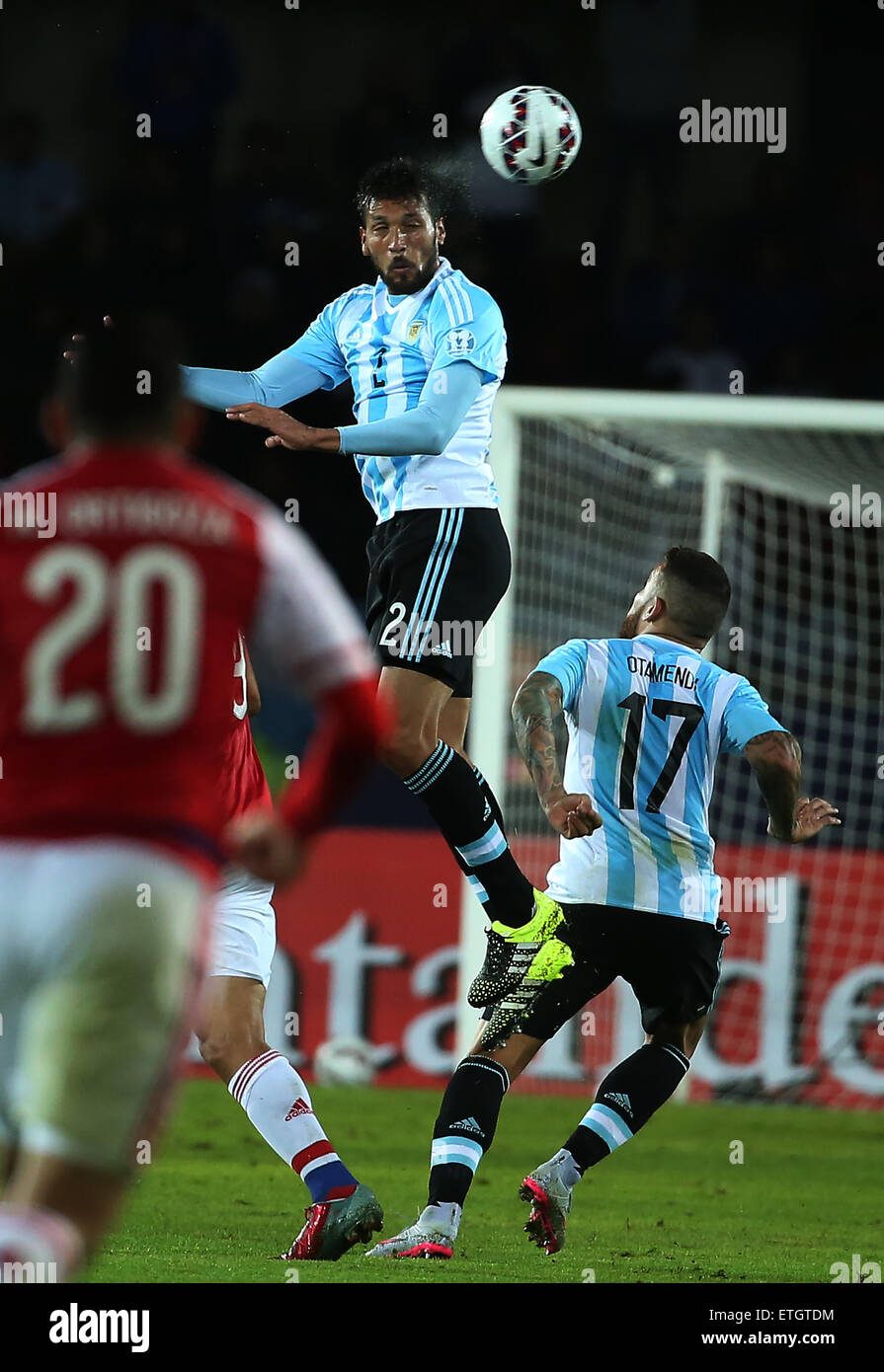 La Serena, Chile. 13th June, 2015. Argentina's Ezequiel Garay (Top) jumps for a head during their Group B match agaisnt Paraguay at Copa America 2015, in La Serena, Chile, on June 13, 2015. The match ended with a 2-2 draw. Credit:  Xu Zijian/Xinhua/Alamy Live News Stock Photo