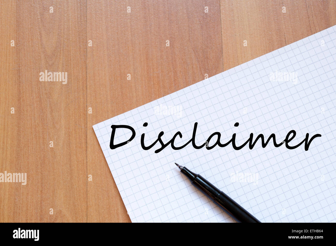 White blank notepad on office wooden table Disclaimer concept Stock Photo