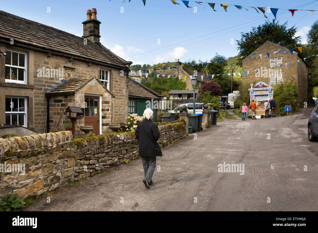 UK, England, Derbyshire, Eyam, Little Edge, visitor walking to see Town Head well dressing Stock Photo
