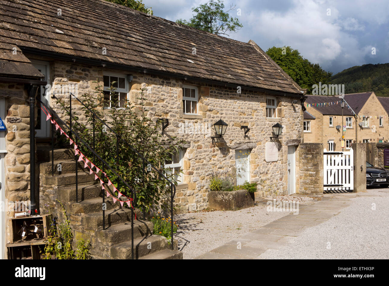 UK, England, Derbyshire, Eyam, Hall courtyard, old stone barns used as craft workshops and offices Stock Photo