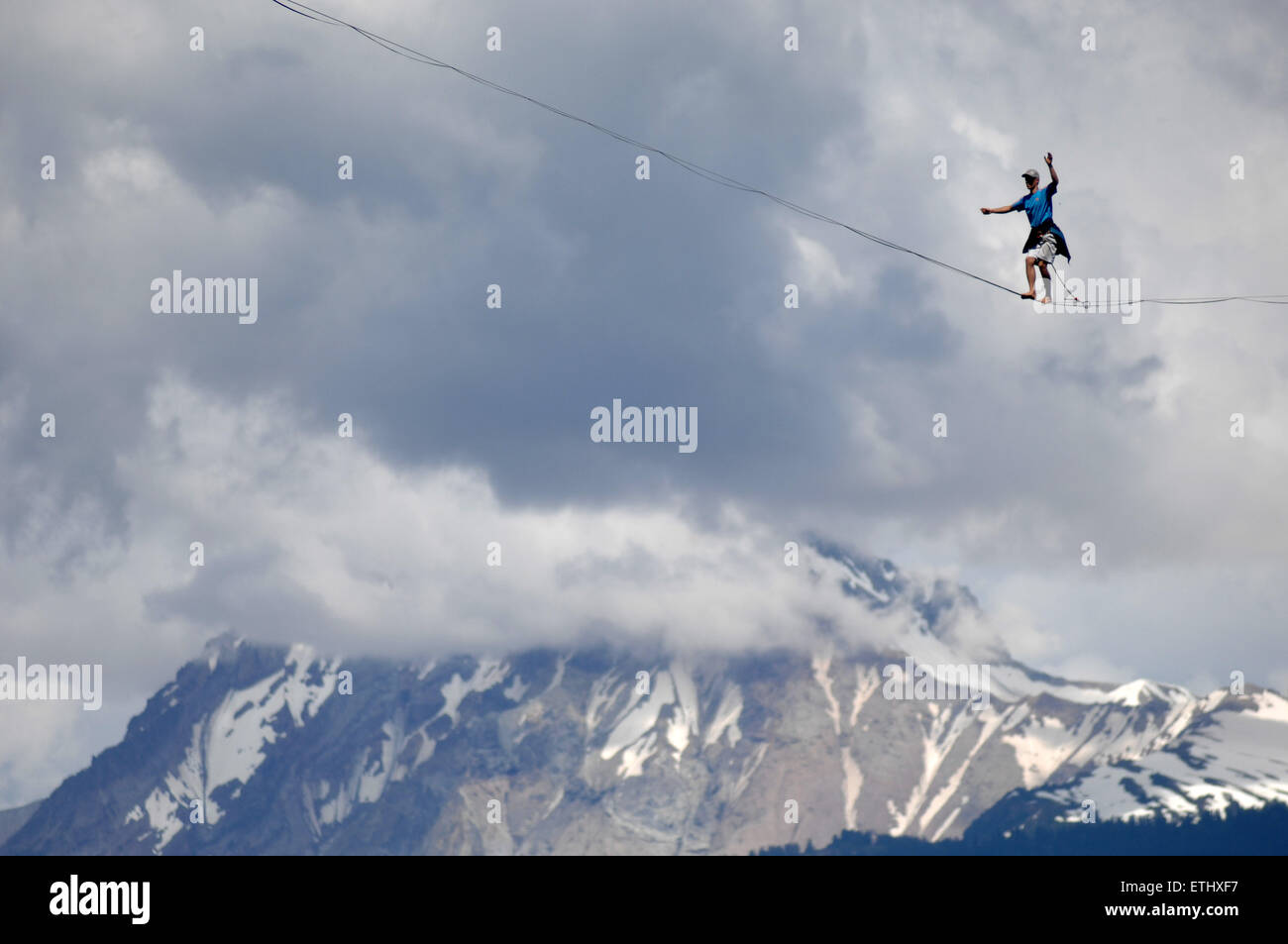 Squamish, Canada. 13th June, 2015. An adventure athlete walks the highline rigged across the gully of the Stawamus Chief peaks during the 2015 International Highlining Meet in Squamish, BC, Canada, on June 13, 2015. Highliners from across the world gather in Squamish to tackle The Chief. Highlining is an extreme sport in which adventurers walk across a rope from one cliff to another. Highlining started in the Yosemite Valley in California. Credit:  Sergei Bachlakov/Xinhua/Alamy Live News Stock Photo