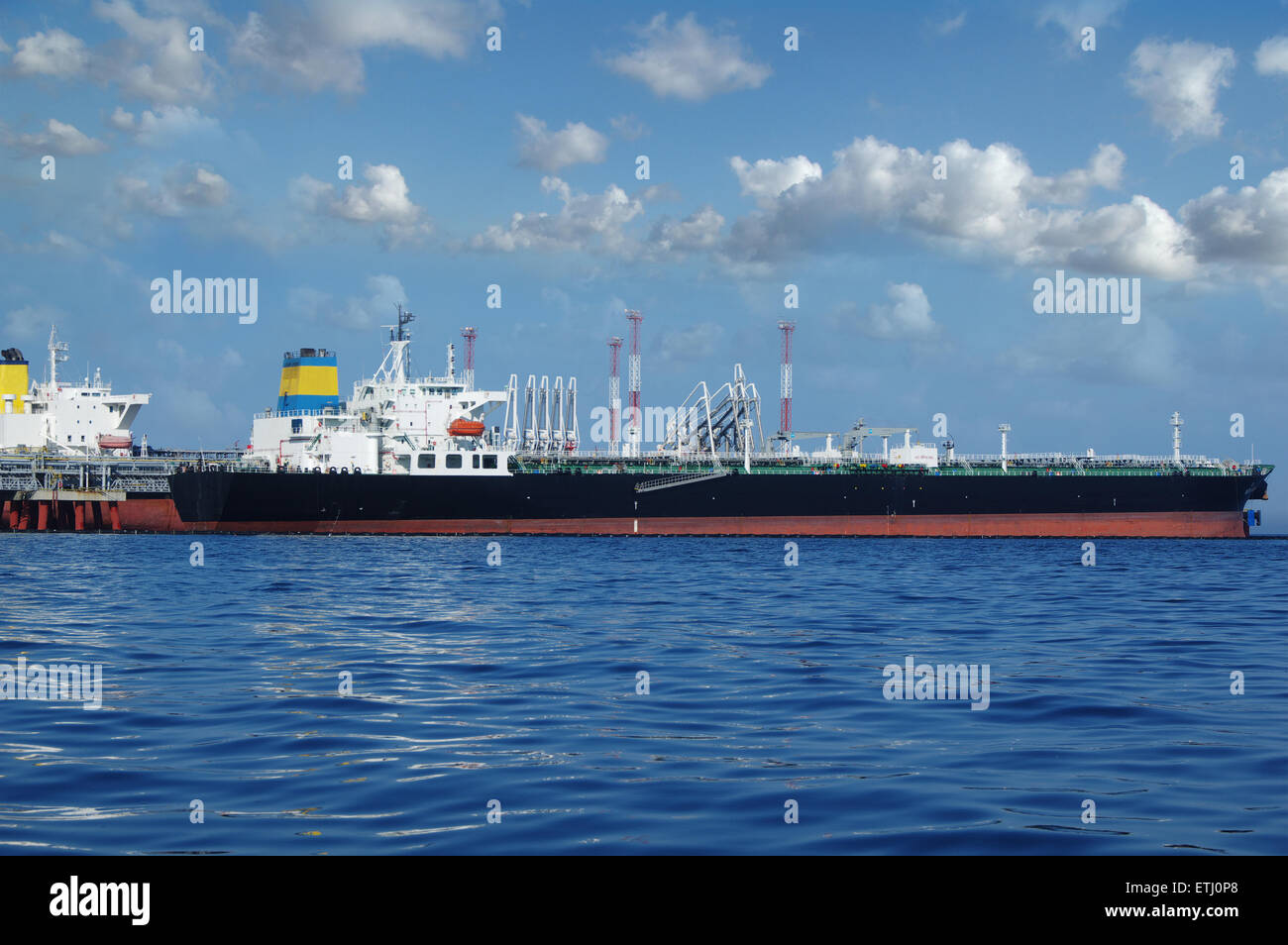crude oil tanker is loading in the port on the background of clouds Stock Photo