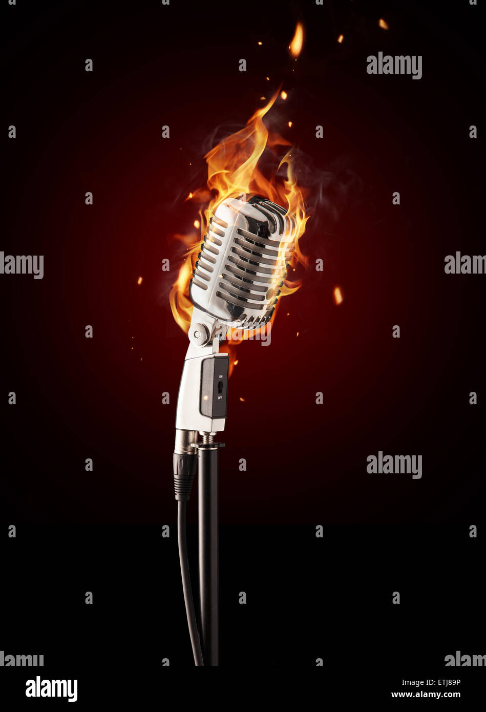Retro singing microphone burning on black background Stock Photo