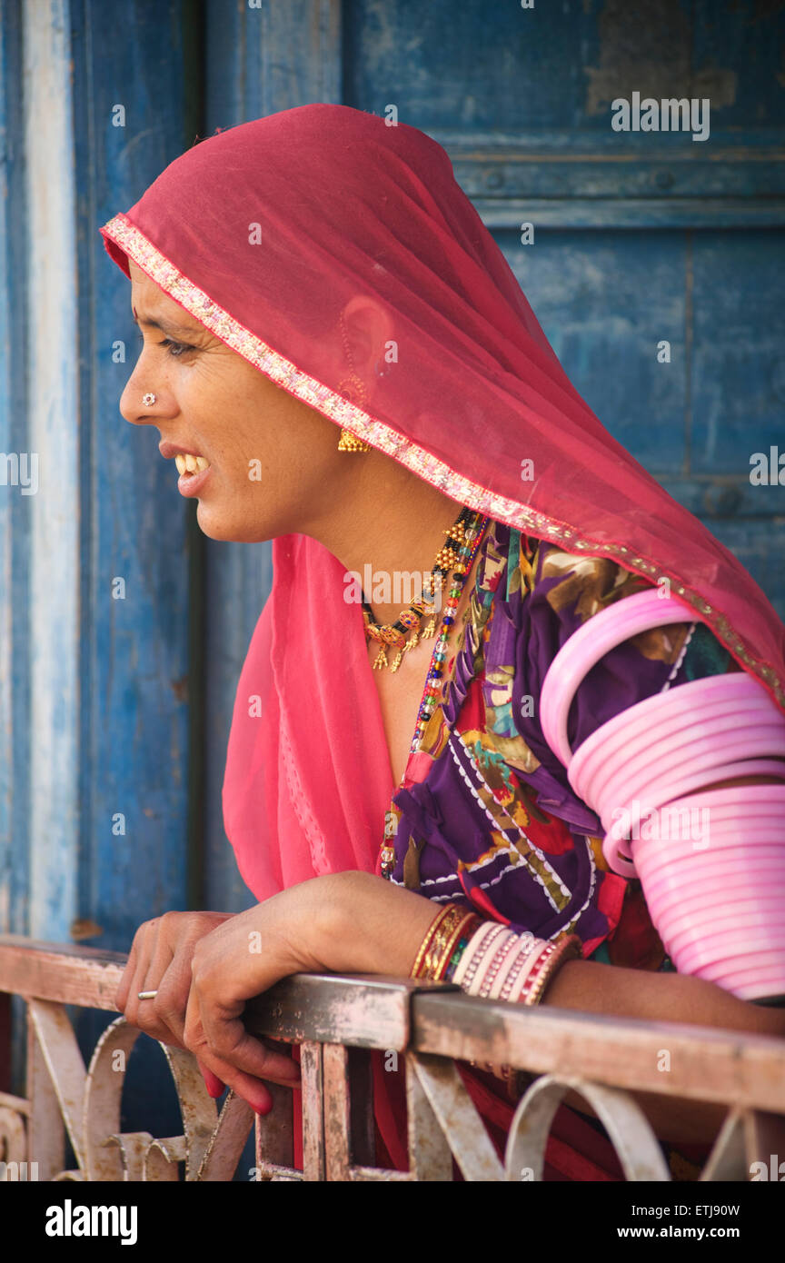 Rajasthani woman in colourful sari at the door to her village home ...