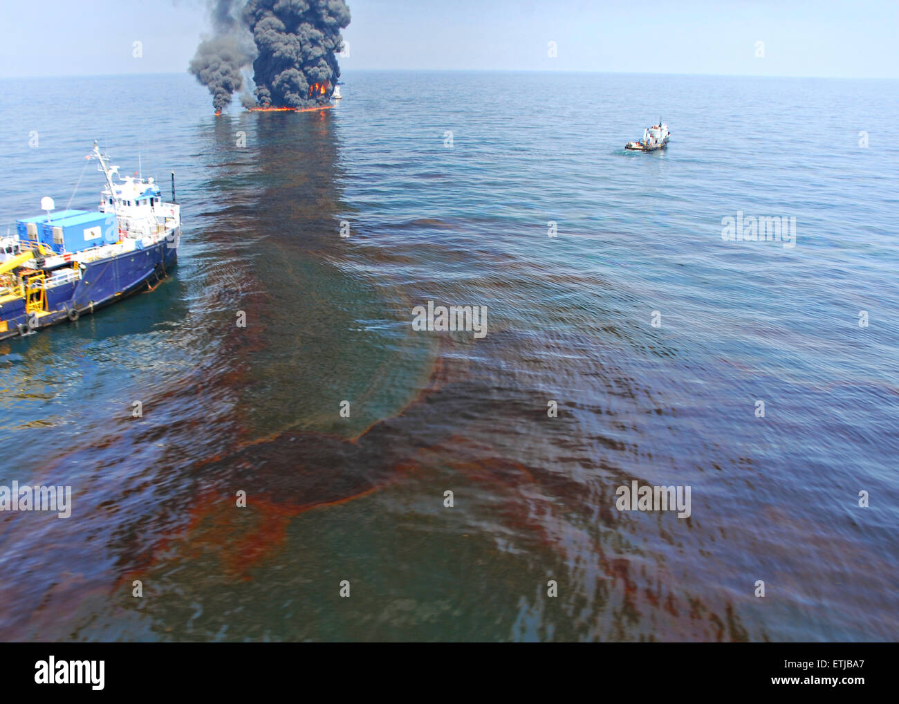 Oil floats on the surface as clean up crews conduct controlled burns following the BP Deepwater Horizon oil spill disaster as efforts to contain and clean the millions of gallons of crew continue June 9, 2010 in the Gulf of Mexico. Stock Photo