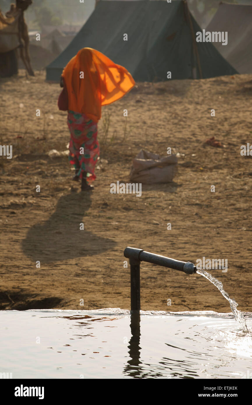 Water trough filling with water from a tap, Camel fair, Rajasthan, India Stock Photo