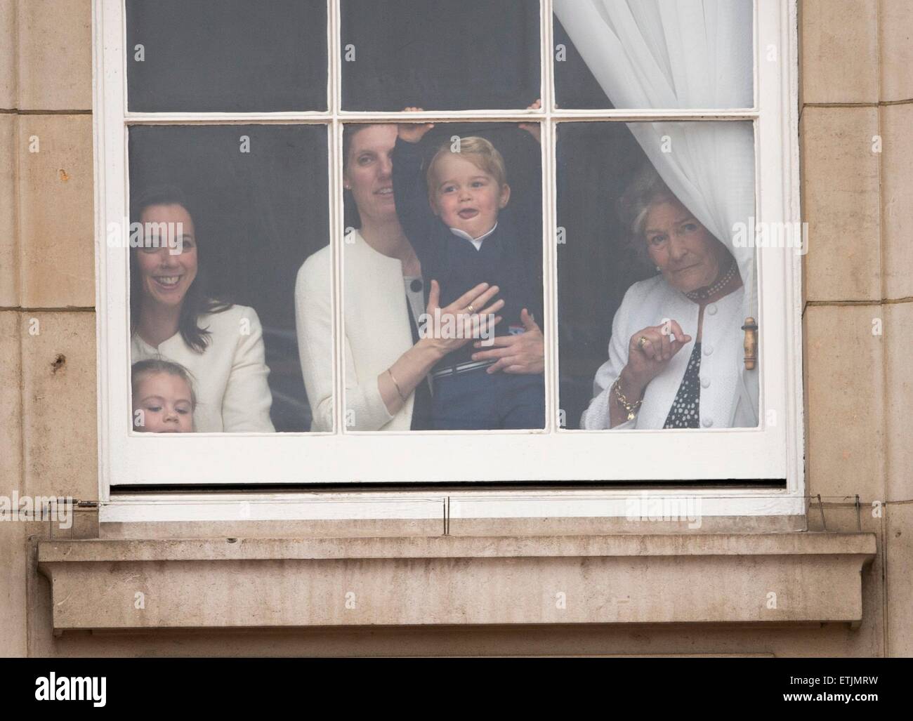 Britian's Prince George is held by a nanny as he waves through a window of Buckingham Palace 13 June 2015 while the Royal Family head for Horse Guards Parade nearby for the annual Trooping the Colour ceremony to mark the monarch's official birthday. Photo: Patrick van Katwijk/ POINT DE VUE OUT - NO WIRE SERVICE - Stock Photo