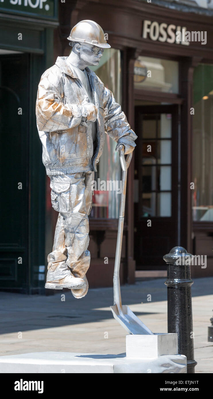 A levitating or floating street artist dressed as a builder resting on