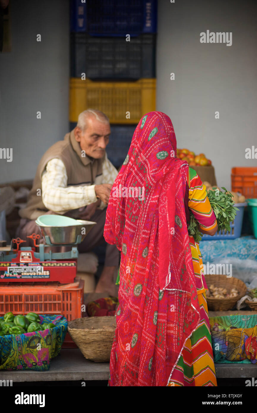 Indian woman in colourful sari buying vegetables at market, Udaipur, Rajasthan, India Stock Photo