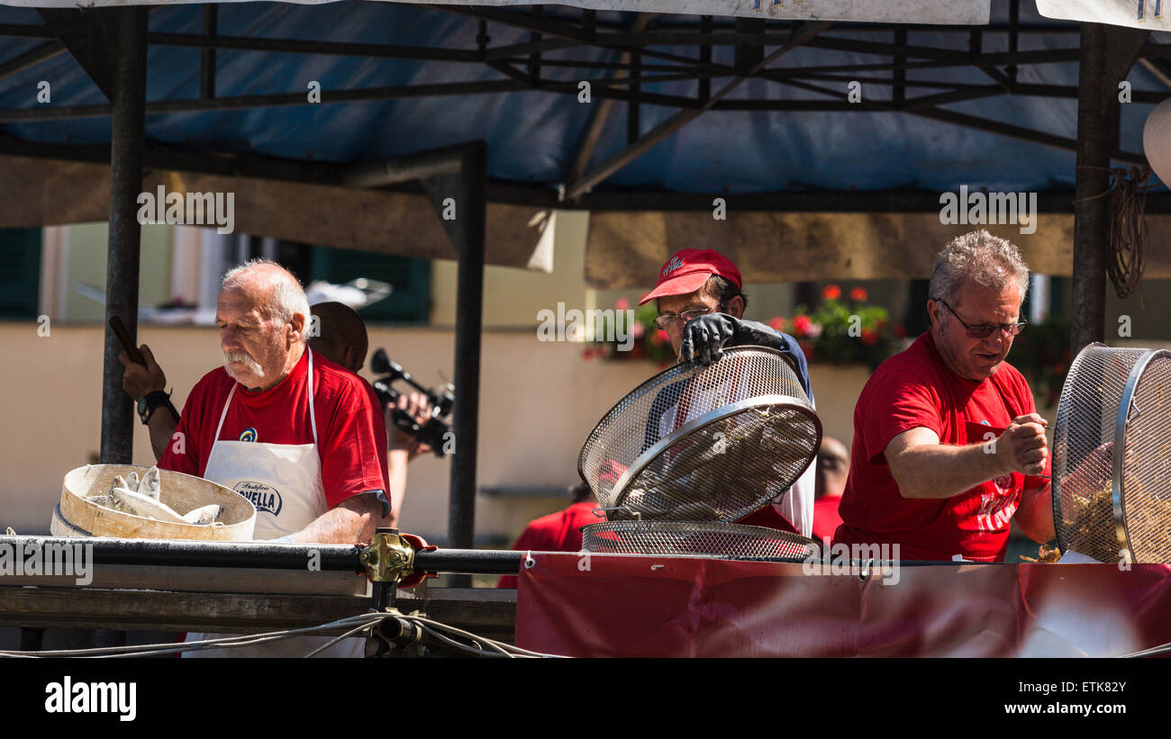 Men fried fish at the Sagre del Pesce festival, Camogli, Liguria, Italy Stock Photo