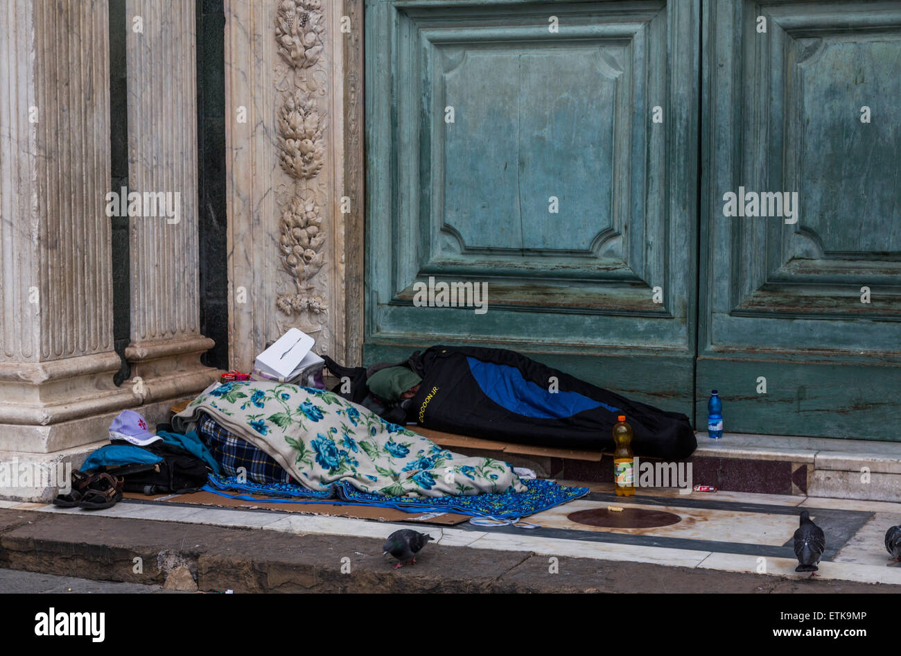 homeless persons in doorway of Santa Maria Novella, Florence, Italy Stock Photo