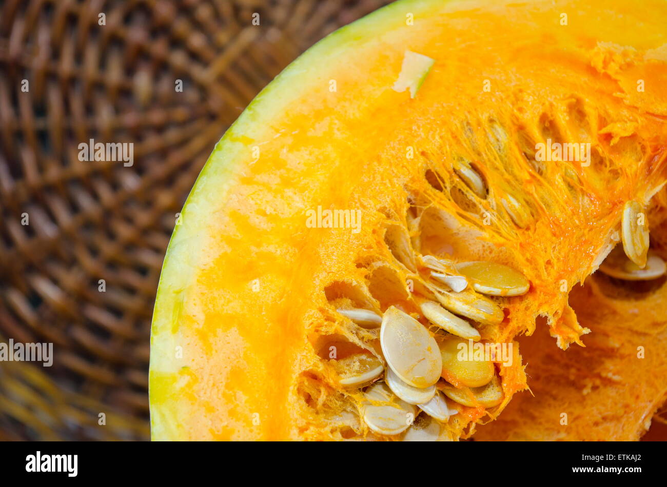 Ripe halved pumpkin against a wooden surface Stock Photo