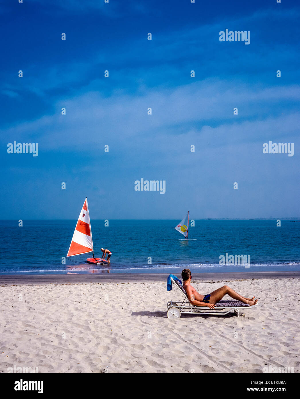 Holidaymaker sunbathing on beach, Gambia, West Africa Stock Photo