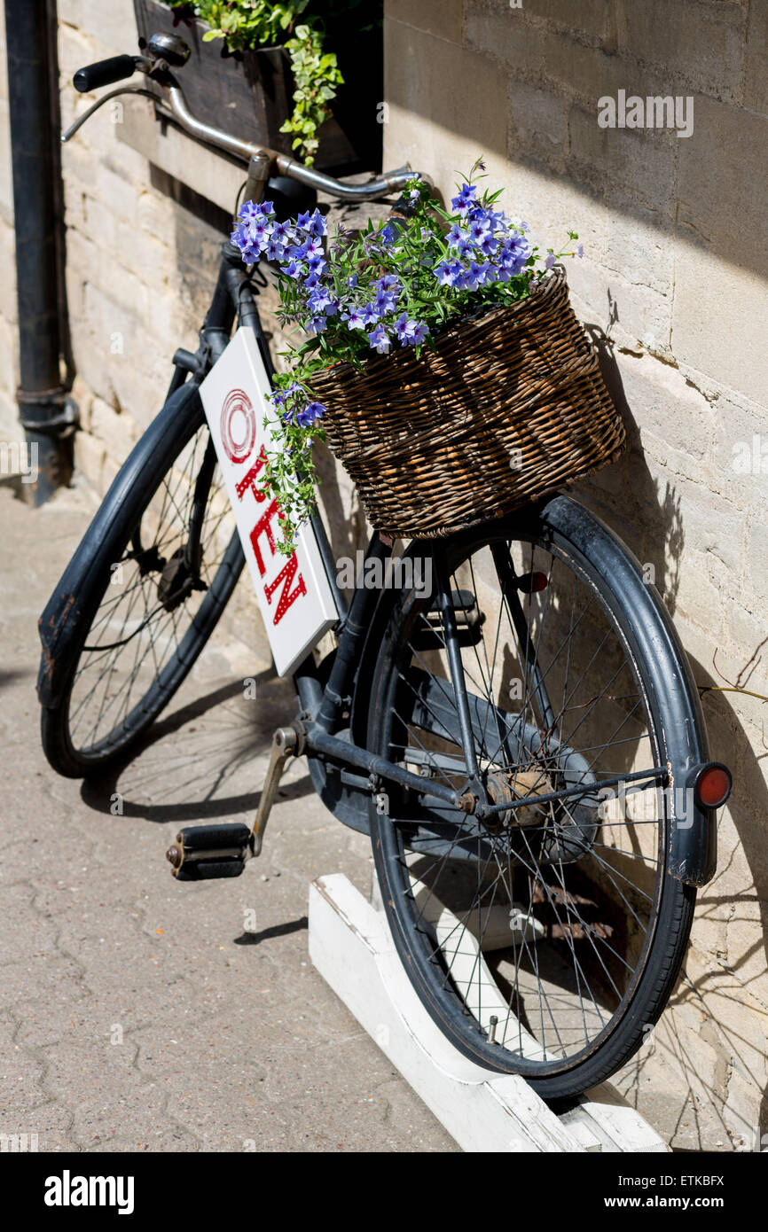 Traditional old bike with basket and open sign outside a shop Stock Photo