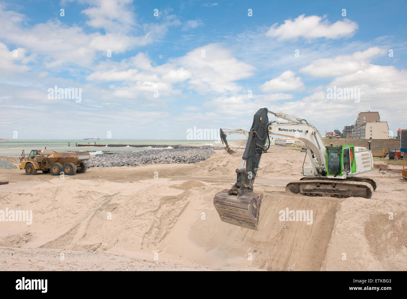 Heavy vehicles working on the coastal protection along the Dutch coast ...