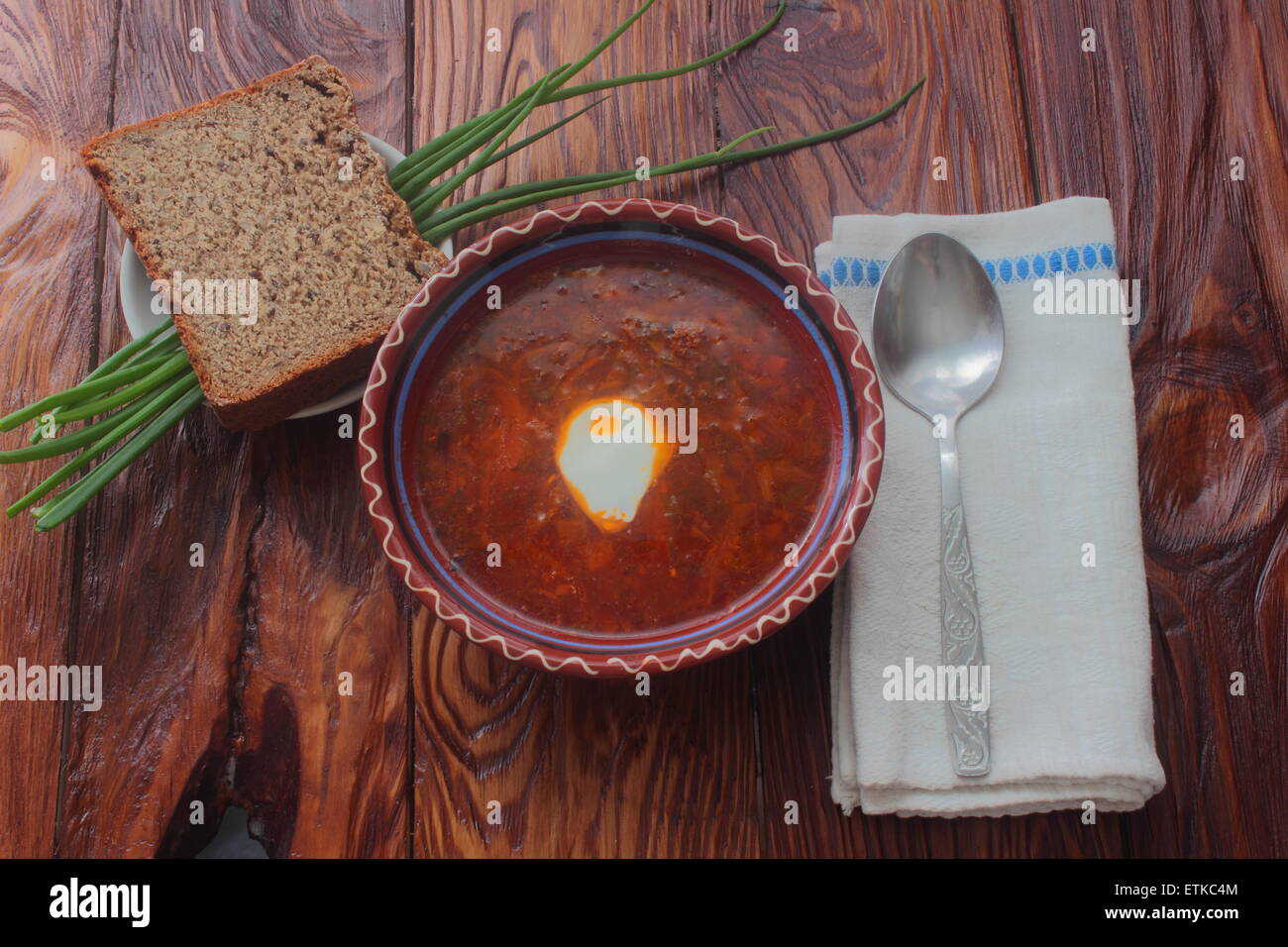 are Ukrainian borscht with sour cream, bread lie with green onions, towel and spoon Stock Photo