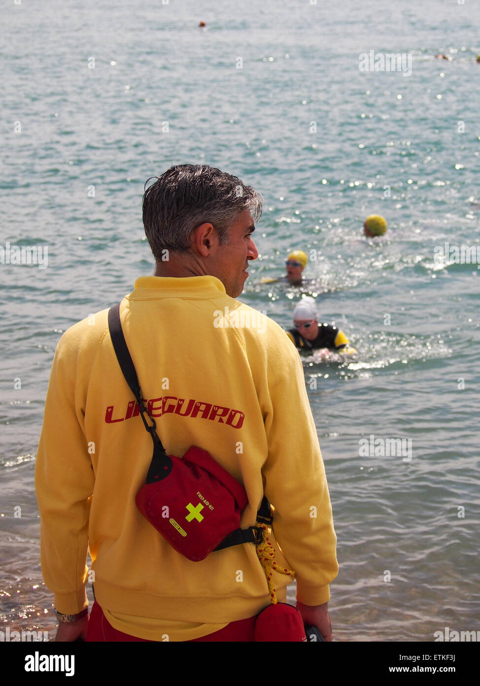 A Lifeguard from the RLSS watches over swimmers in the Solent from Southsea beach, Portsmouth, England Stock Photo