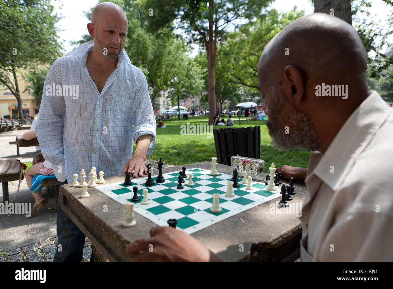Men playing chess in public park table - DuPont Circle, Washington, DC USA Stock Photo