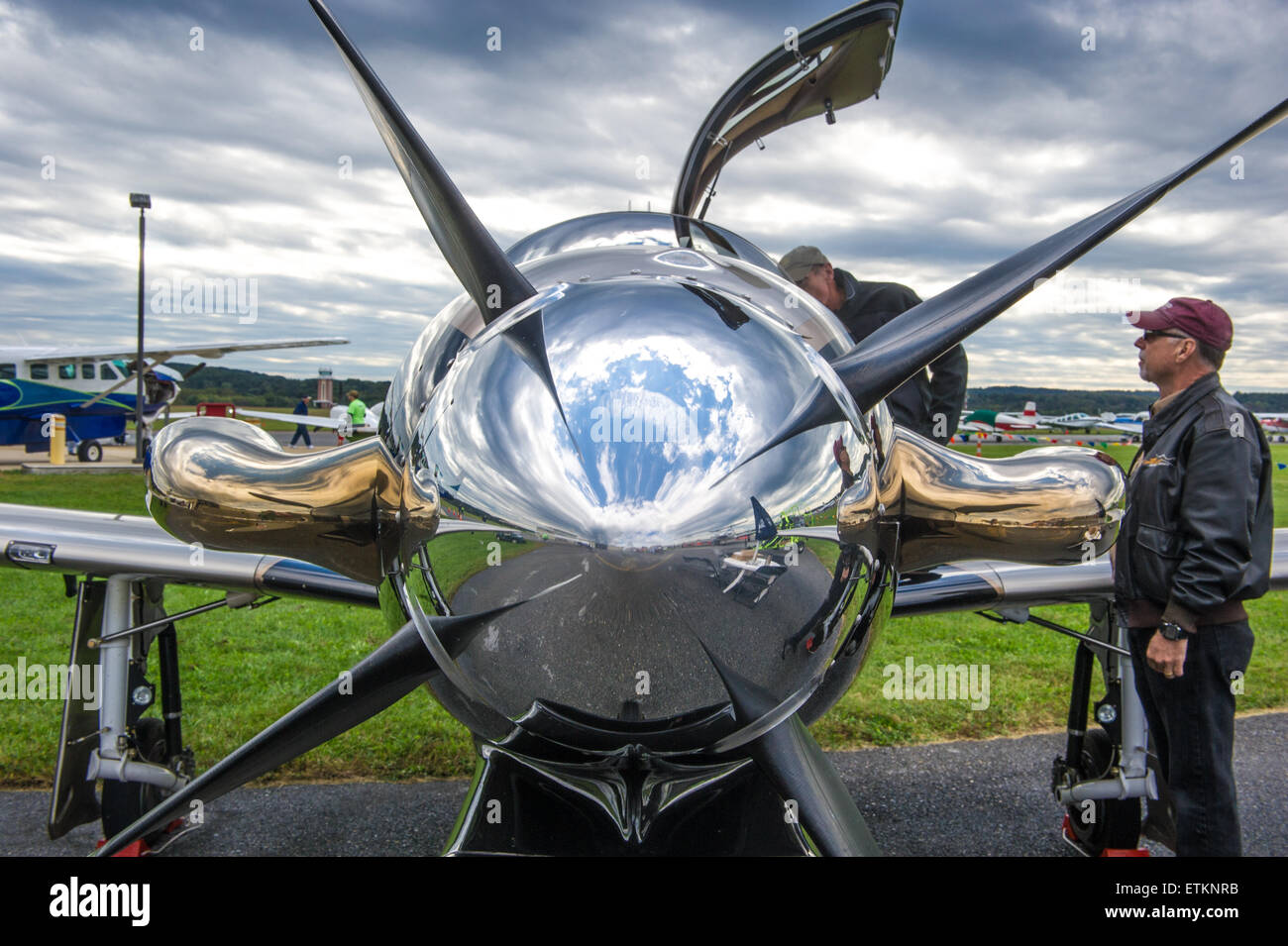 Close-up of shiny nose of airplane with two men observing in Creswell, Maryland, USA Stock Photo