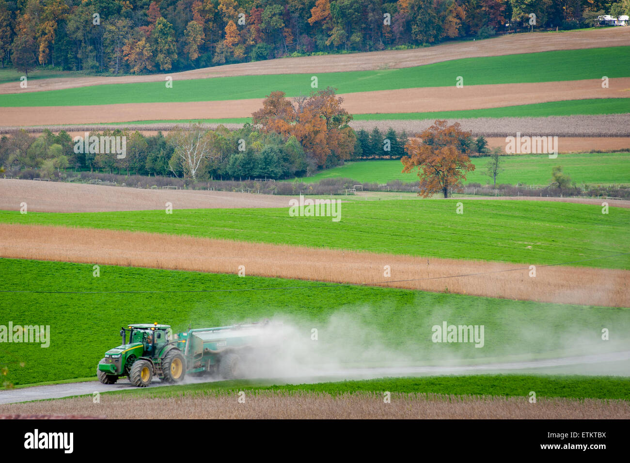Tractor driving down the road followed by a lot of dust in Union Bridge, Maryland, USA Stock Photo
