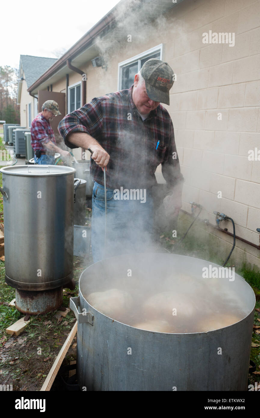 Men boiling stuffed hams outside, in large pans in St Mary's County
