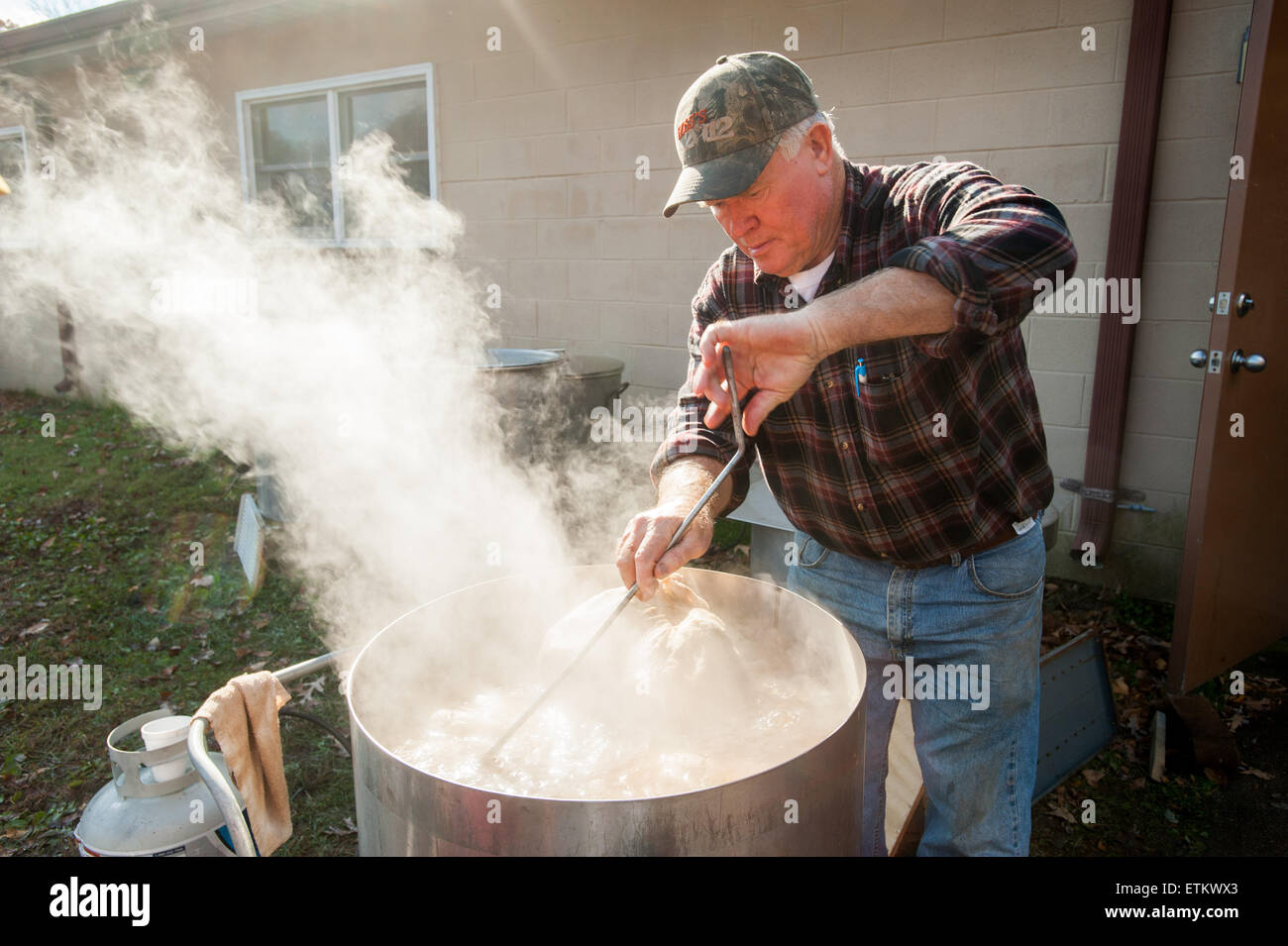 Man boiling stuffed hams outside, in large pans in St Mary's County, Maryland, USA Stock Photo