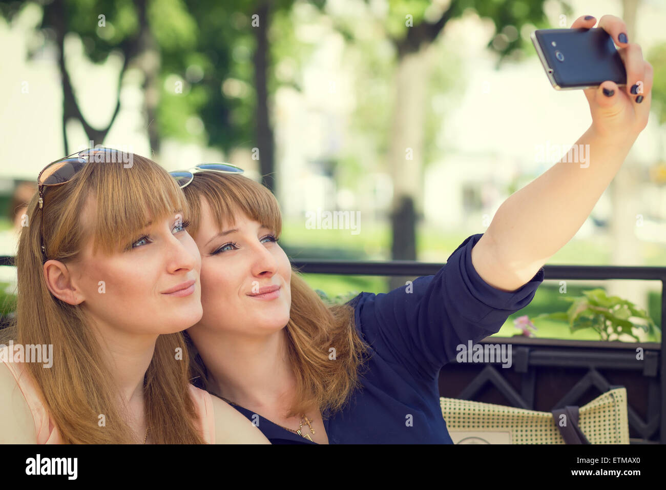 Twins Sisters Taking Selfie With Mobile Phone In A Restaurant Young