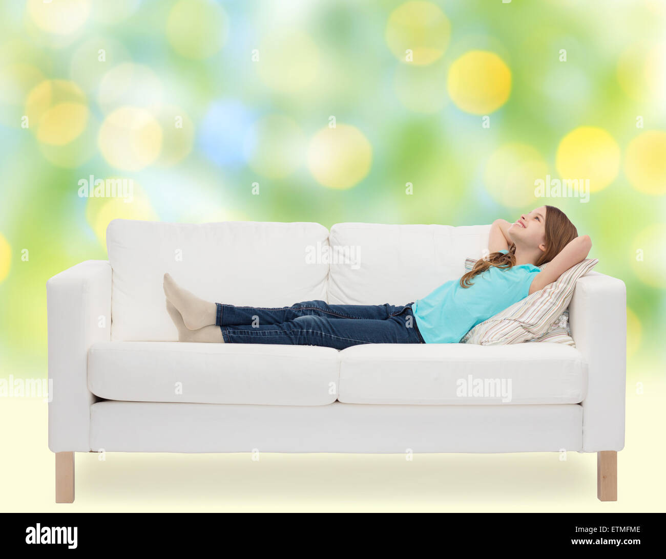 smiling little girl lying on sofa and dreaming Stock Photo - Alamy