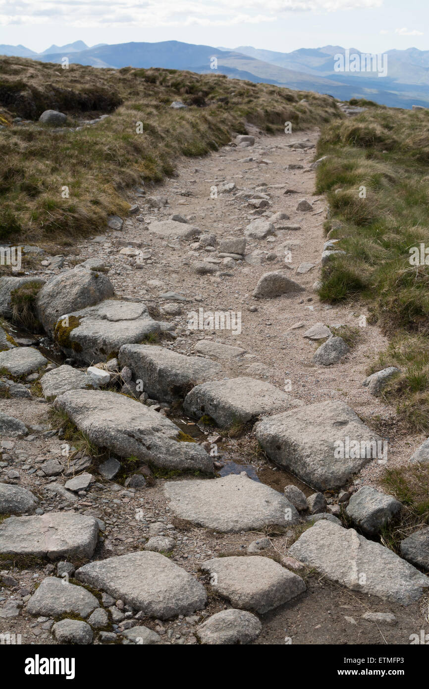 Upland path drainage technique - Stone Cross-drain on footpath on Aonach Mor, Fort William, Scotland, UK Stock Photo