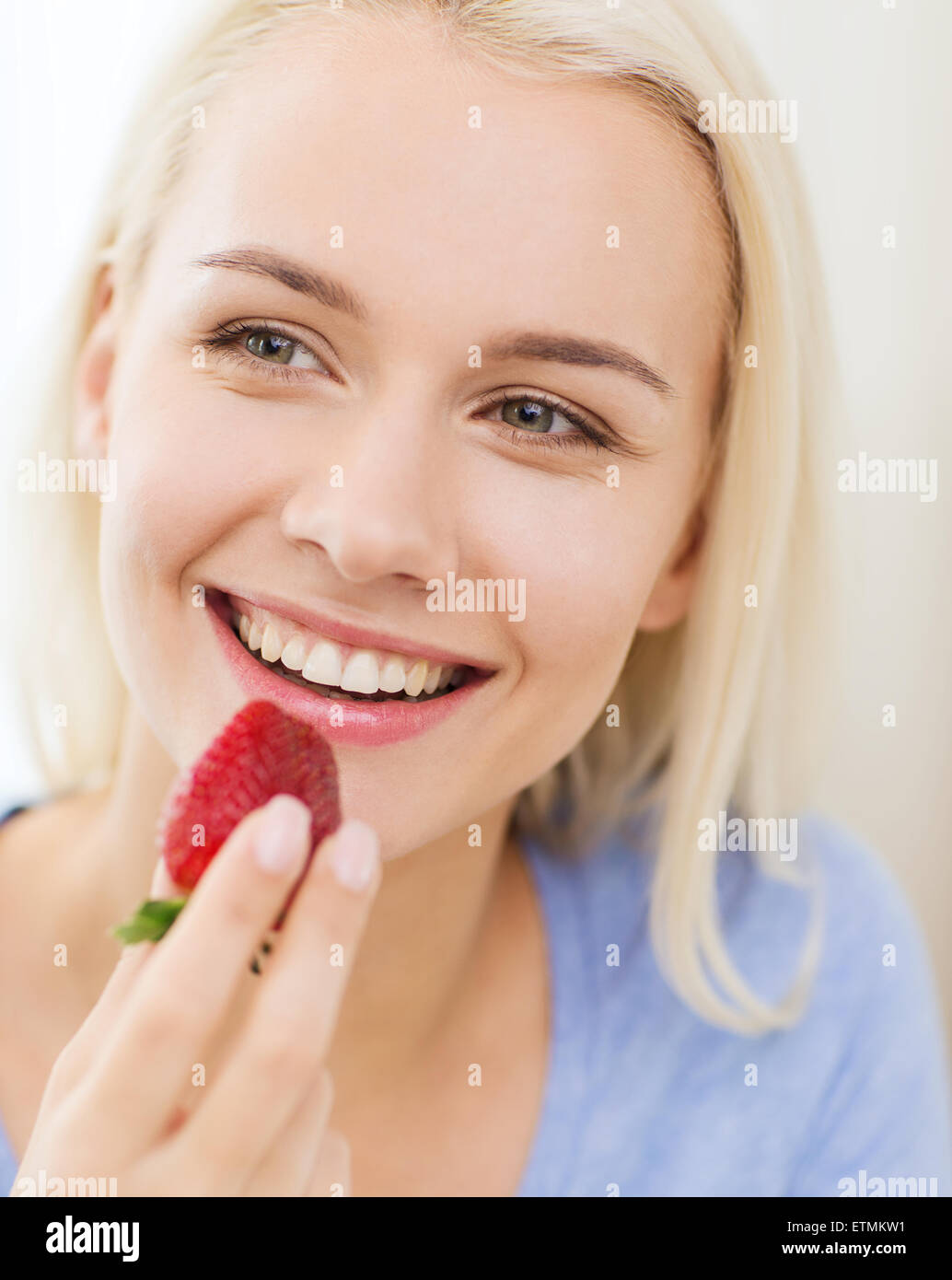 happy woman eating strawberry at home Stock Photo Alamy