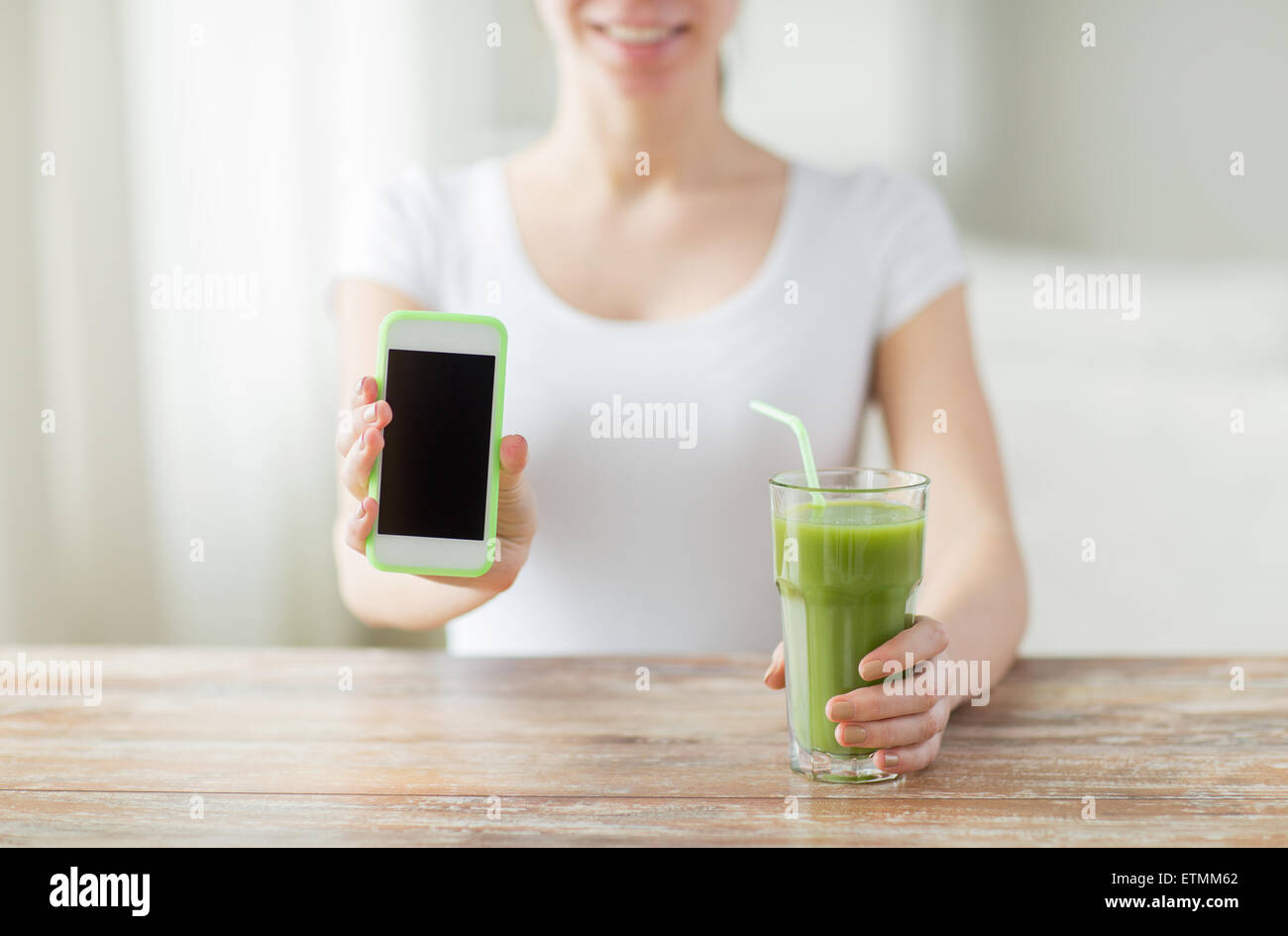 close up of woman with smartphone and green juice Stock Photo