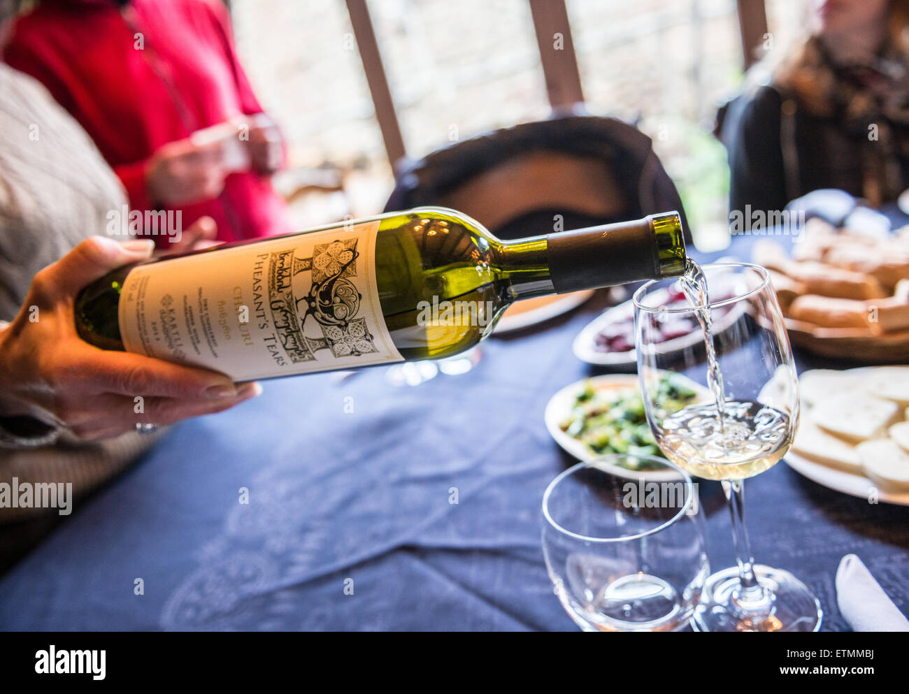 Woman pouring white Chinuri wine in Pheasant’s Tears - small local winery in Sighnaghi town, Kakheti region of Georgia Stock Photo