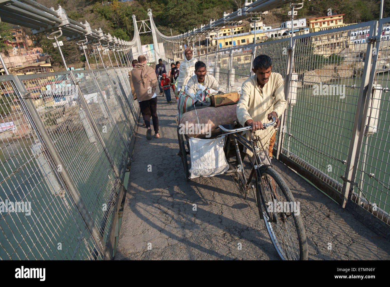Men pushing loaded bicycle across the Ram Jula bridge in Rishikesh Stock  Photo - Alamy