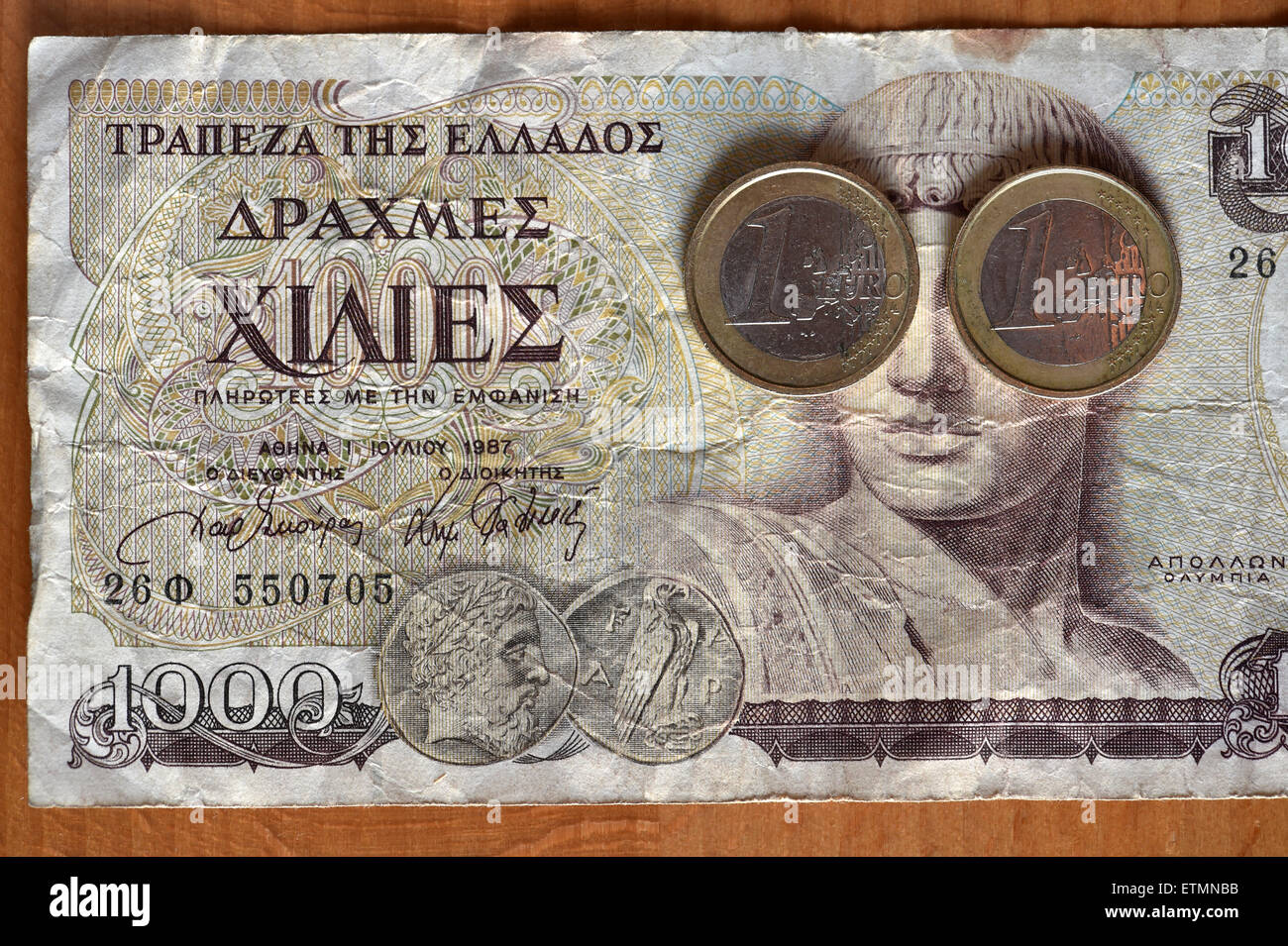 Berlin, Germany. 14th June, 2015. ILLUSTRATION - Two one euro coins cover the eyes of Greek god Apollo on a 1000 Greek drachma bill in Berlin, Germany, 14 June 2015. Photo: Jens Kalaene/dpa/Alamy Live News Stock Photo