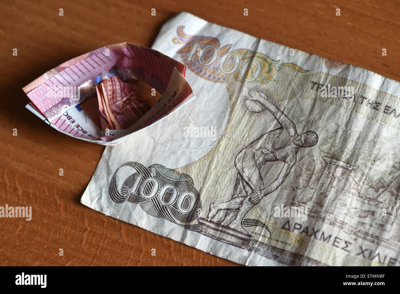 Berlin, Germany. 14th June, 2015. ILLUSTRATION - A ten euro bill which has been folded into a boat lies on a 1000 Greek drachma bill in Berlin, Germany, 14 June 2015. Photo: Jens Kalaene/dpa/Alamy Live News Stock Photo