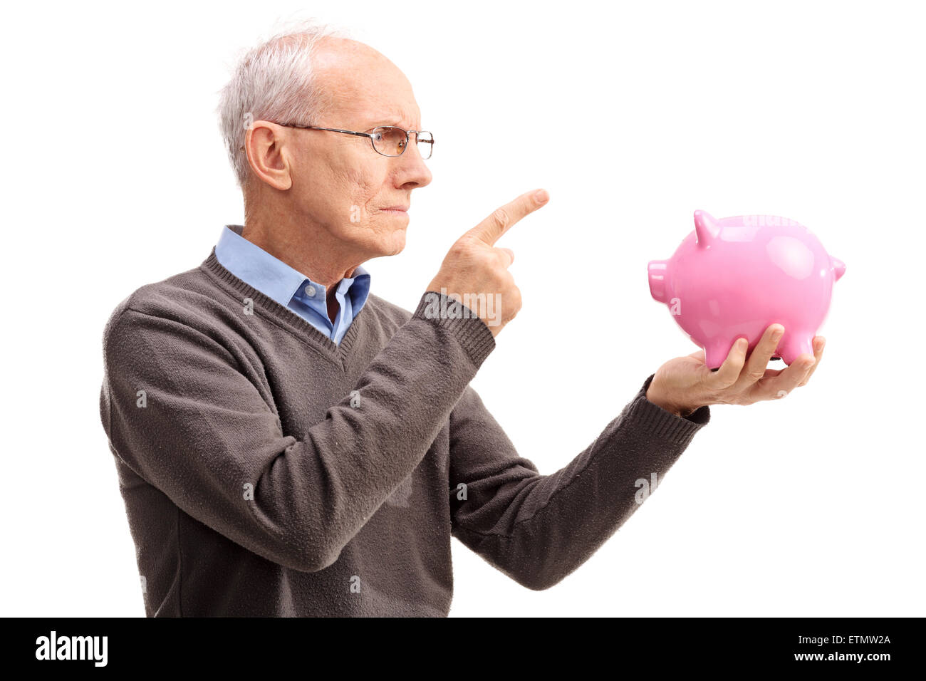 Studio shot of an angry senior scolding a piggybank isolated on white background Stock Photo