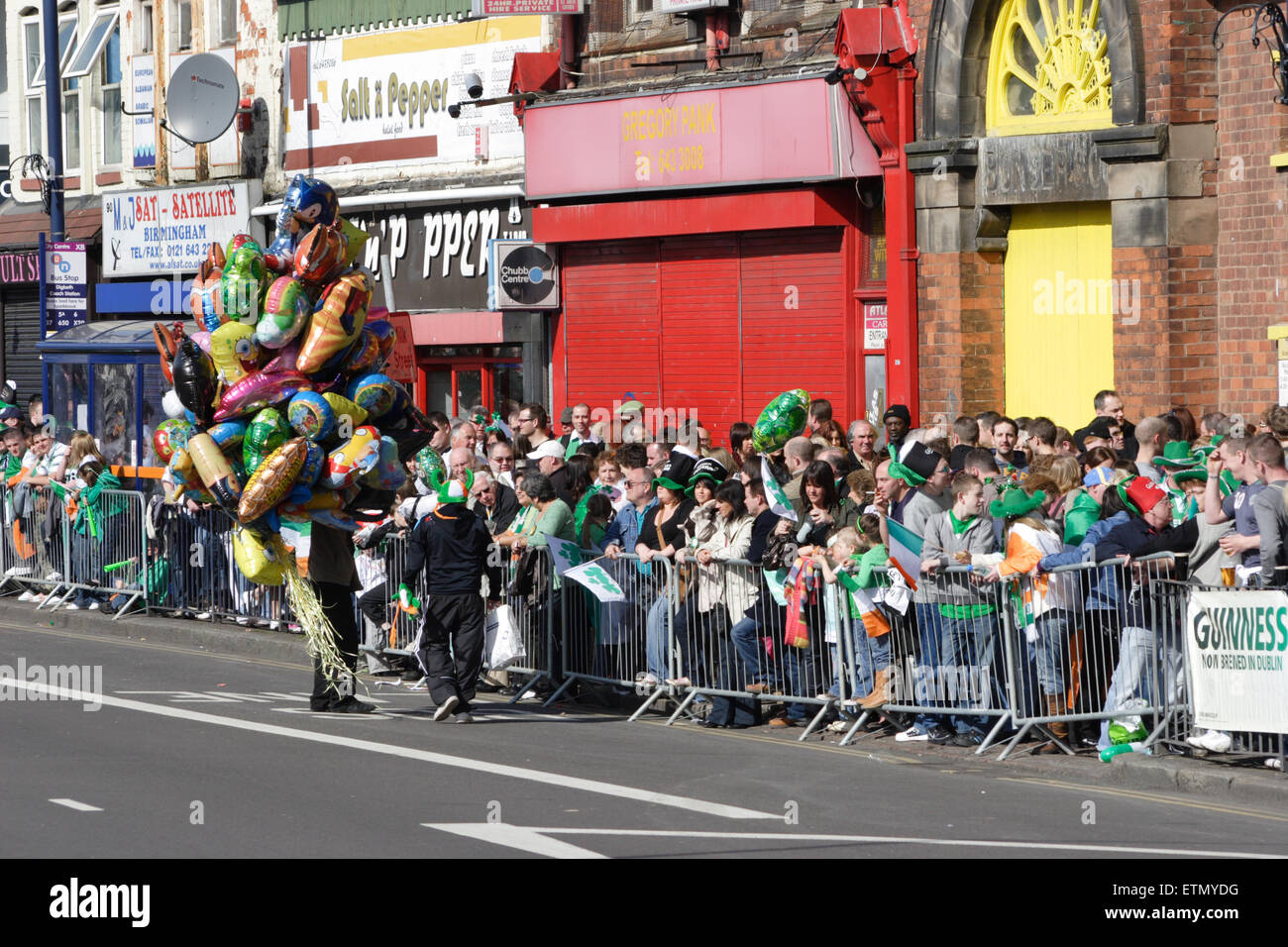 a balloon seller with the crowds awaiting the precession at Birmingham's St Patrick's Day parade Stock Photo