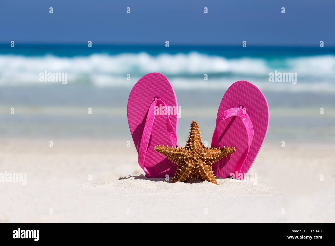 Pink flip flops and starfish on white sandy beach. Summer vacation ...
