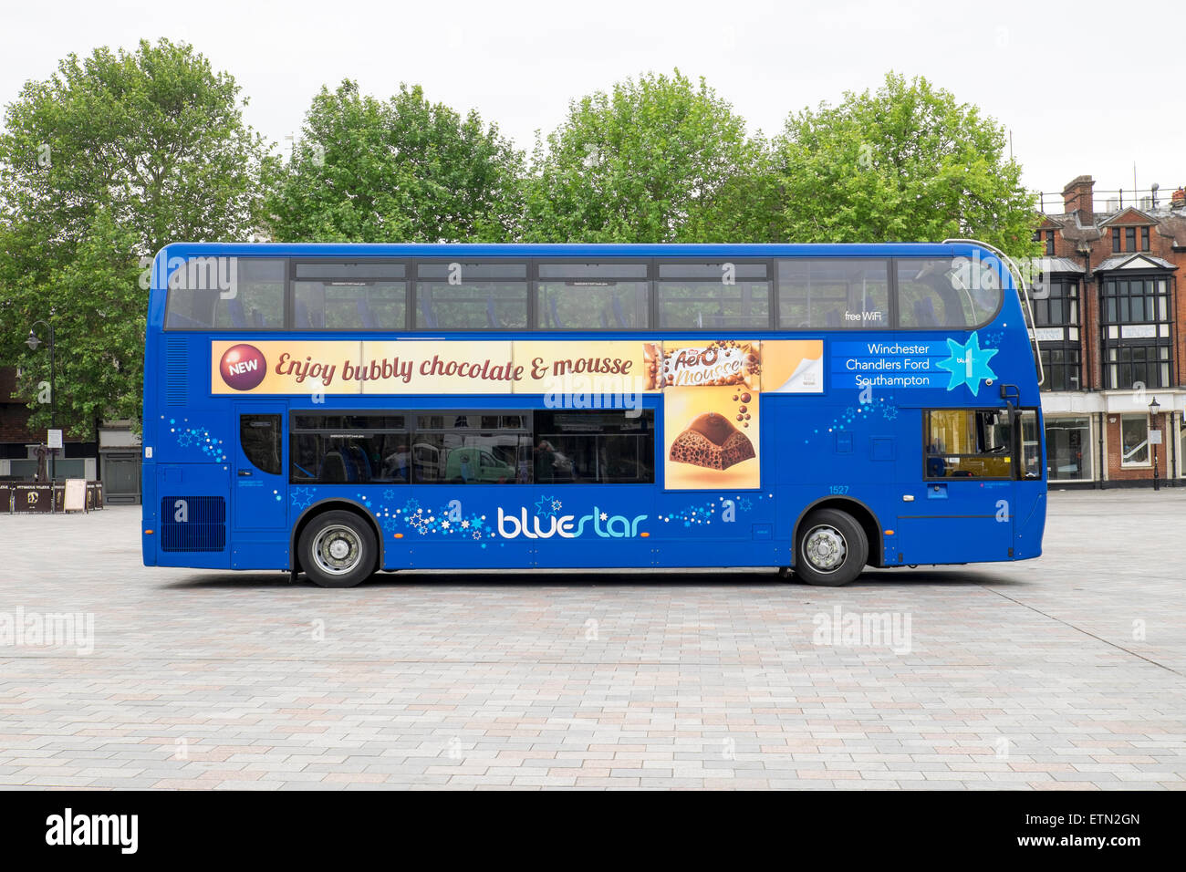 Advertising posters on the side of a blue UK double decker bus Stock Photo